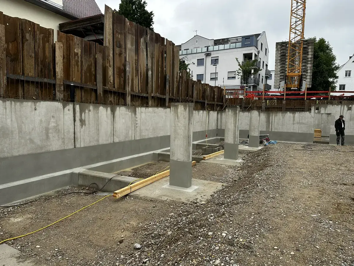Baugrube mit Holzverbau, Betonwänden und Stützen.