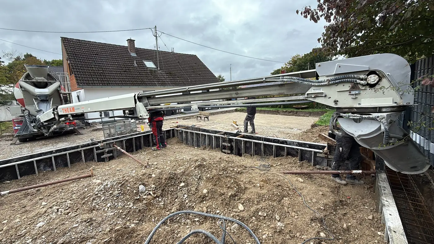 Baustelle mit Betonfertigteilen und Kran.